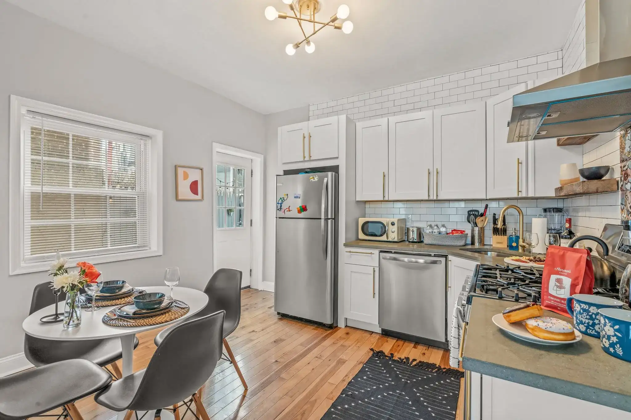 Modern kitchen with stainless appliances, subway tile, and bold pops of art—fully stocked for cooking and entertaining.
