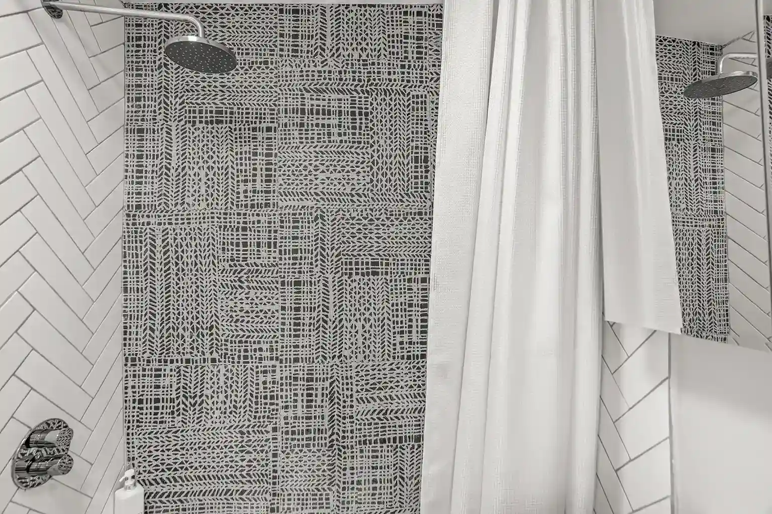 Spa-like shower with a rainfall head and bold patterned tile for a refreshing retreat.