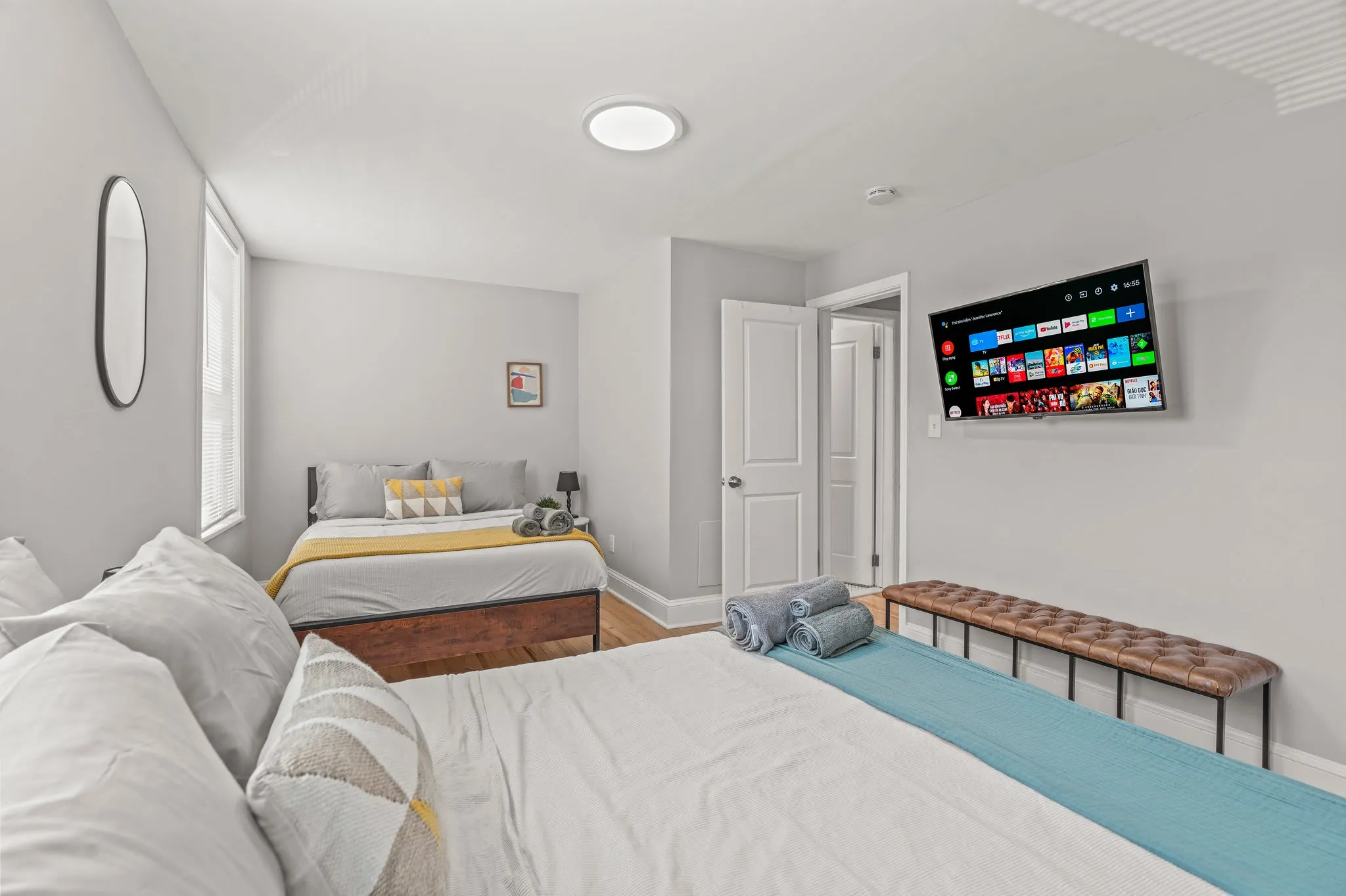 Unwind with streaming on the mounted smart TV—both beds offer plush comfort and stylish touches.