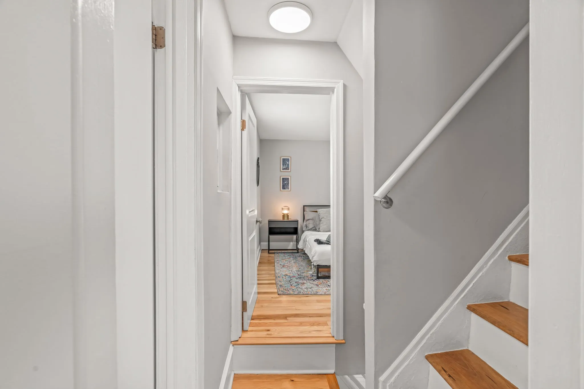 Charming hallway leads into a private bedroom retreat with warm lighting and inviting décor.