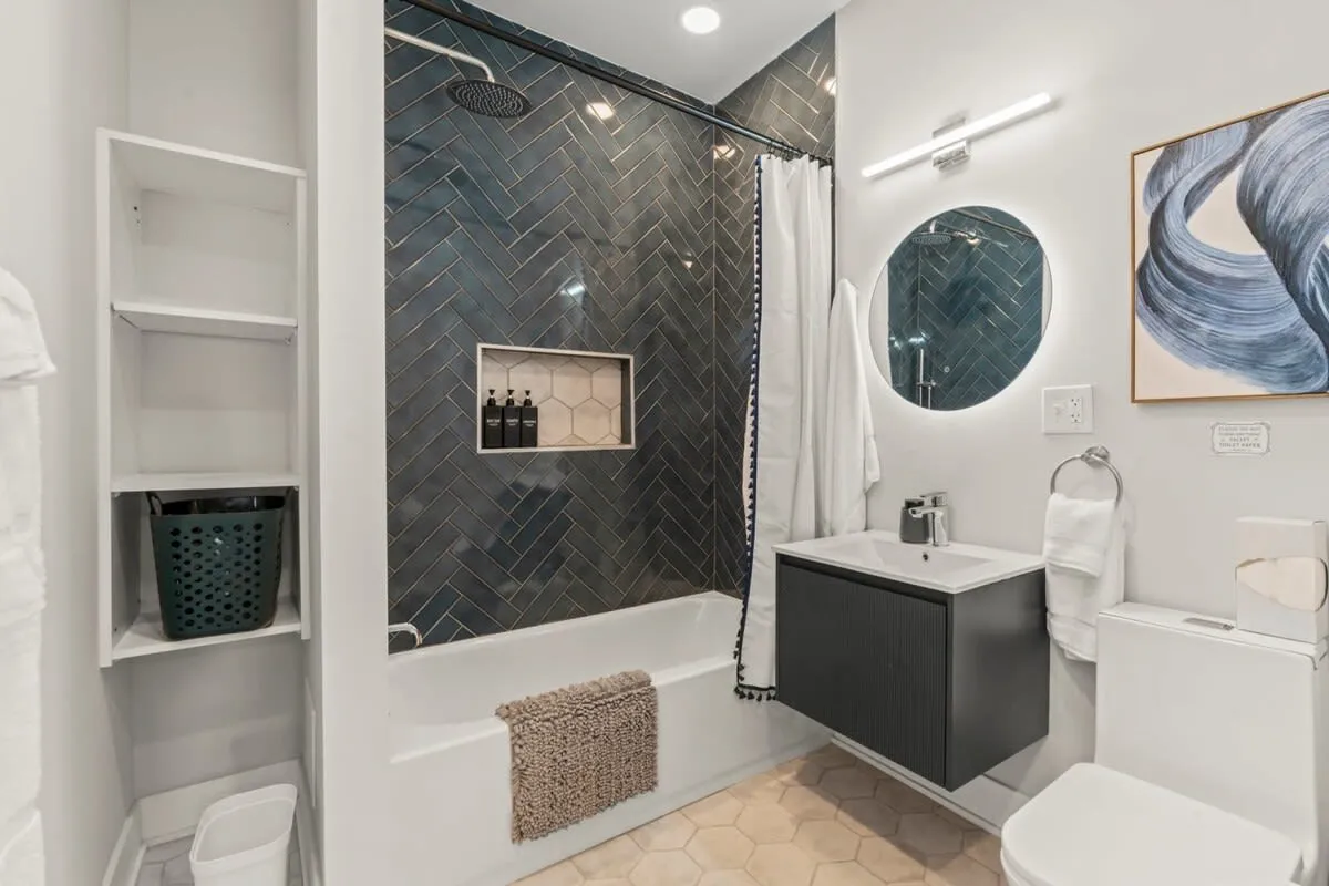 Sleek and modern, this spa-inspired bath features bold tilework, a rainfall shower, and designer finishes that elevate every stay.