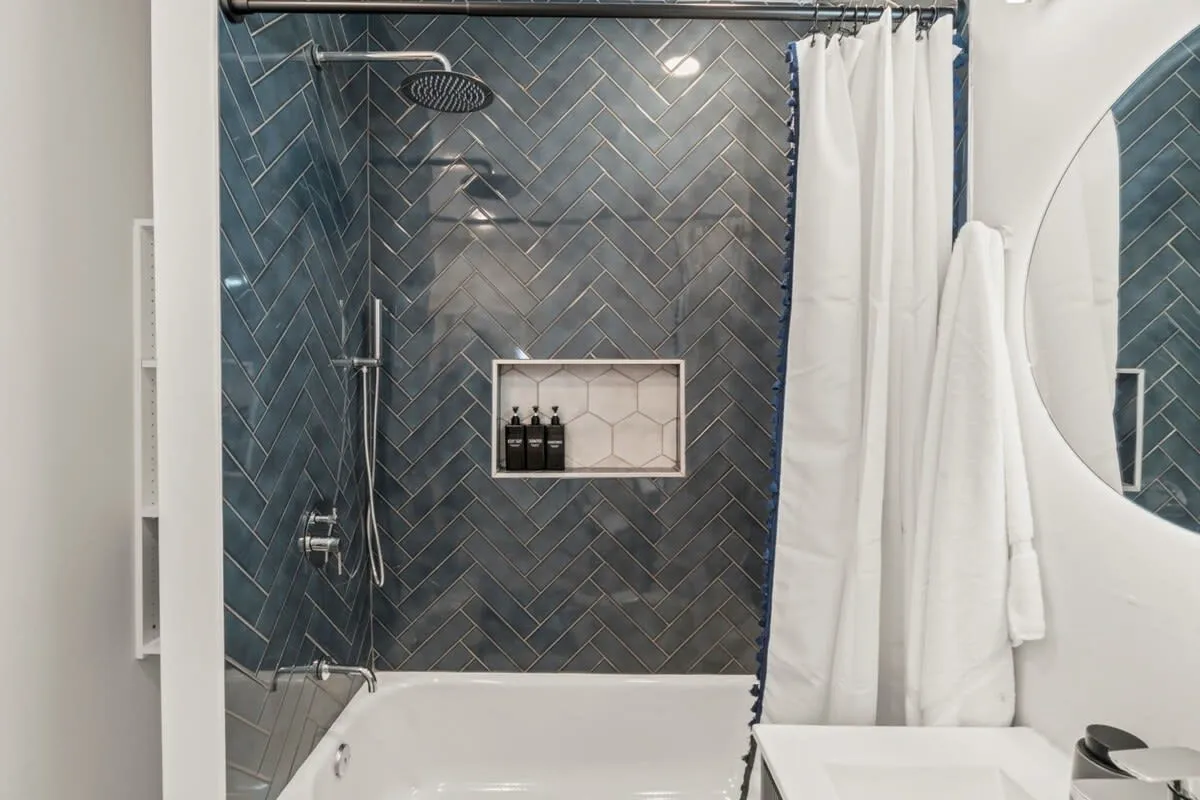 Enjoy hotel-quality touches with a rainfall shower, herringbone tile, and luxe bath products for a refreshing reset.