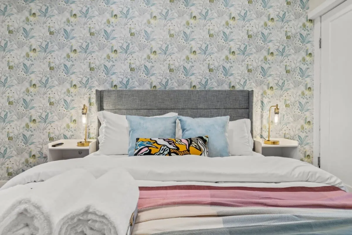 Crisp linens, layered hues, and golden light create a space that feels both soothing and sophisticated.