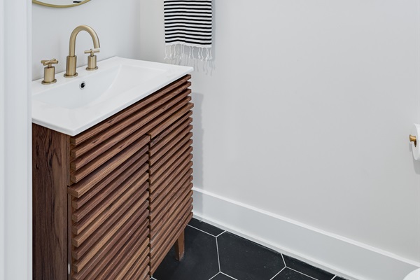 A modern half bath with warm wood, matte black details, and a minimalist design that feels effortlessly chic.