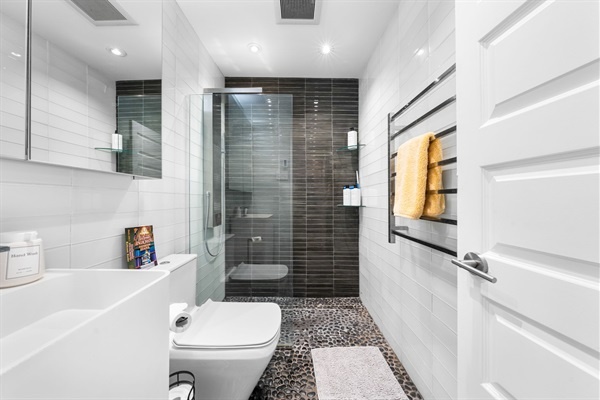 Fresh, spa-inspired design with sleek tile and rainfall shower—refresh and reset in coastal style.