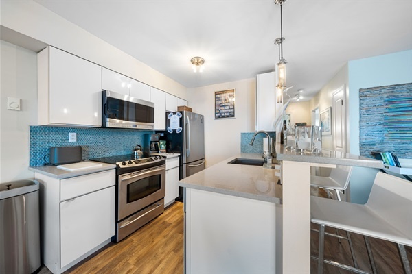 Cook up ocean-view memories in this sleek, fully equipped kitchen with modern finishes and beachy charm.