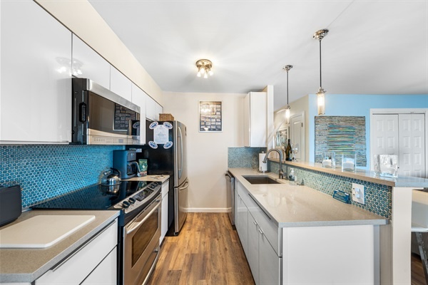 Eat in after a great day at the beach!  The kitchen features gorgeous white cabinets and quartz countertops.