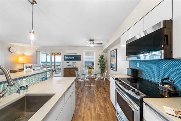 Cook, sip, and connect in this stylish kitchen with ocean-inspired tile and sleek stainless finishes.
