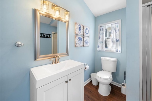 Roomy vanity and natural light with a full glass shower—simple, clean, and beach-day practical.