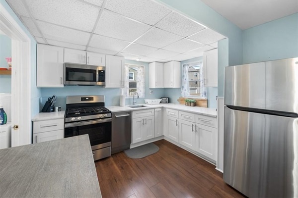 Cook, chat, and sip—this open kitchen blends coastal charm with stainless steel style.