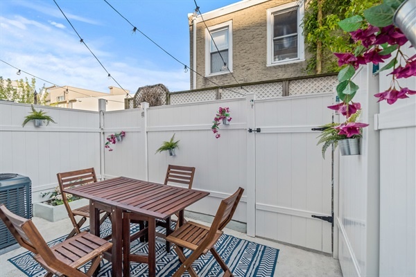 Enjoy morning coffee or evening drinks on this private patio with twinkling lights and cozy seating for four.