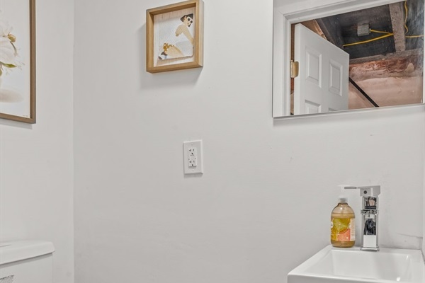 Convenient half bath downstairs, spotless and stocked with essentials—because comfort matters in every corner.