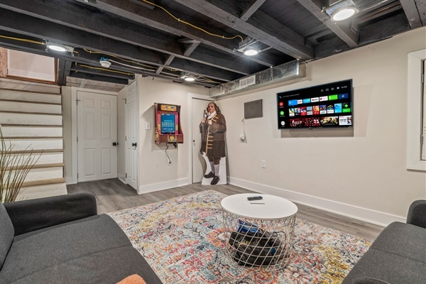 Step downstairs to your cozy game den—complete with streaming TV, retro charm, and space to unwind after a day exploring Philly.