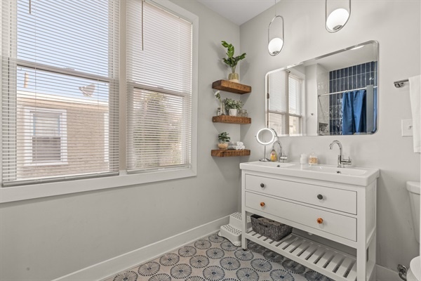 This spacious bath features a double vanity, stylish lighting, and plenty of natural light for a fresh, spa-like feel.