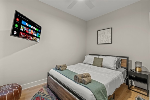 A peaceful retreat with a queen bed, soft linens, and a mounted Smart TV — unwind in comfort after a day in the city.