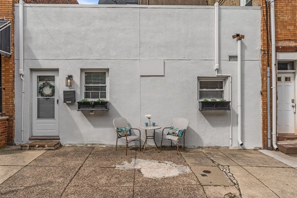 You will love the charming outdoor seating area, perfect for enjoying a morning coffee or evening drink. Relax and soak up the neighborhood's atmosphere in this inviting space.