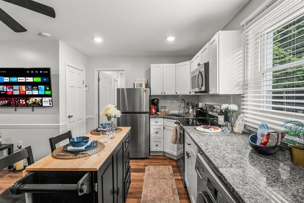 Appreciate the convenience and charm of this open kitchen layout. The sleek appliances and thoughtful design create an inviting space where you can cook, dine, and relax in comfort.