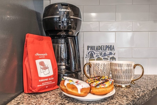 You will love starting your mornings with freshly brewed coffee from the Cuisinart coffee maker, accompanied by delicious donuts and beautifully designed mugs. This setup adds a touch of warmth and local charm.