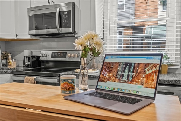 Enjoy working or relaxing in this bright, modern kitchen. The cozy island, with fresh flowers and a Philadelphia-themed coffee mug, provides the perfect spot for a cup of coffee and some quality time.