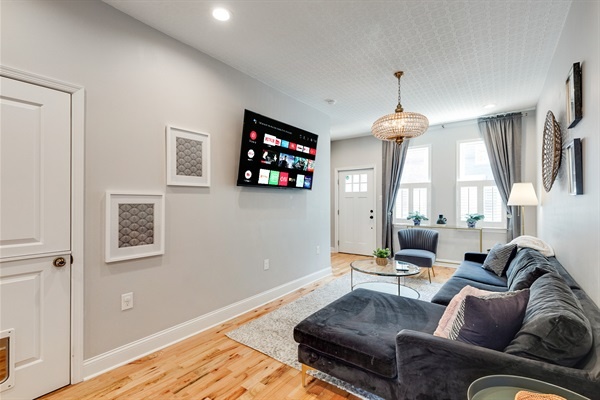 Sunlight pours in through tall windows, highlighting plush seating and elegant textures throughout.