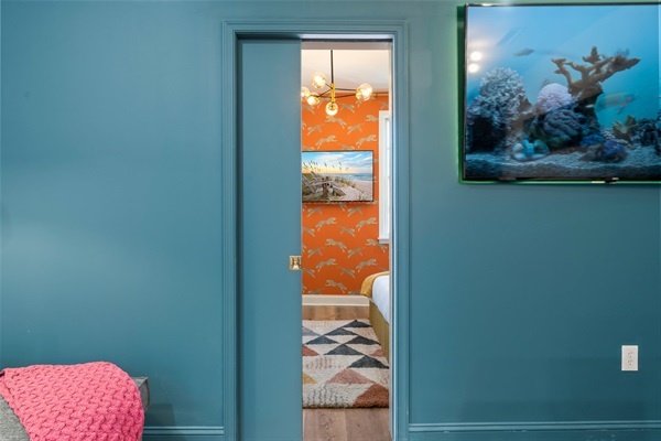 A pop of energy awaits — step from the calm teal living room into this playful, personality-packed bedroom.