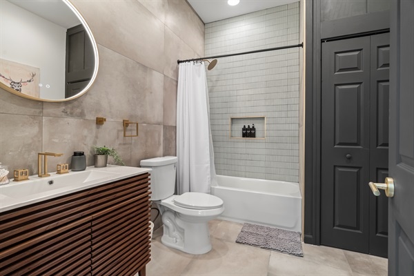 Step into your spa-like bathroom—sleek tile, gold fixtures, and everything you need to refresh and unwind.  A stackable washer and dryer is located in the closet for your convenience!