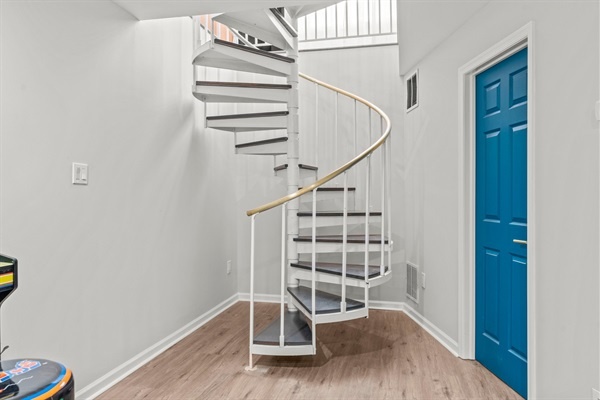 Admire the elegant spiral staircase, adding a touch of sophistication and unique charm to the space. It’s a stylish and practical feature that enhances the overall aesthetic.