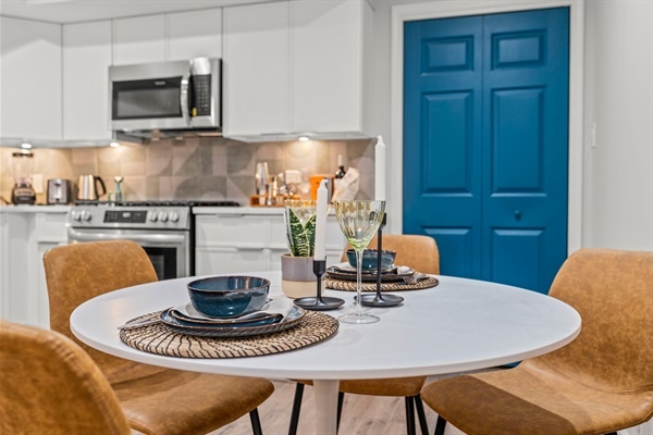 Enjoy a cozy meal at this stylish dining table, set with chic dishware and a touch of greenery. It’s a perfect spot for a romantic dinner or a relaxed breakfast.