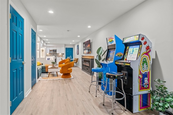 Enjoy the open and inviting layout of this modern living area. The arcade games, cozy seating, and bright decor create a fun and comfortable environment for relaxation and entertainment.
