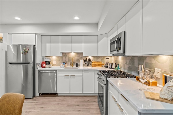 Step into a sleek, modern kitchen featuring elegant gold accents, high-end stainless steel appliances, and ample counter space. Perfect for culinary adventures and creating memorable meals dur