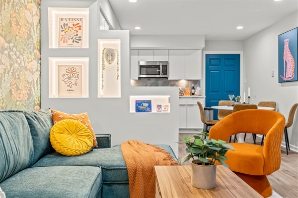 Relax in this vibrant and cozy living room, complete with a large TV, stylish furniture, and a colorful accent wall. It’s a perfect place to unwind and enjoy your favorite shows or movies.