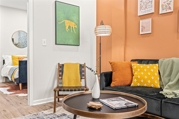 Immerse yourself in a stylish, cozy living area with comfortable seating, colorful cushions, and unique decor. Enjoy the modern art and inviting ambiance, perfect for unwinding and creating me