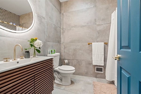 Modern tile and designer gold finishes in this gorgeous bathoorm!