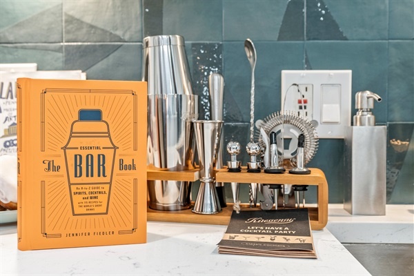 You will appreciate the stylish and fully equipped bar area, perfect for crafting your favorite cocktails. With "The Bar Book" by Jennifer Fiedler as your guide, you'll have everything you need to mix like a pro. Enjoy the sleek bar tools and access