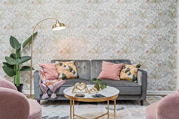 Our vibrant living space, complete with a stylish wallpaper and plush seating, invites you to relax and enjoy your stay. The blend of colors and textures creates a warm, welcoming atmosphere.