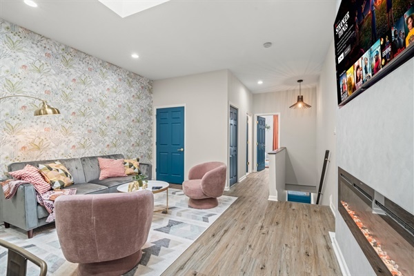 Step into our chic living room, where style meets comfort! Sink into plush seating, enjoy the warmth of the modern fireplace, and immerse yourself in your favorite shows on the large smart TV.