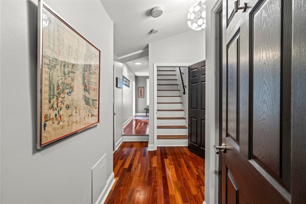 Welcome to your home away from home! This charming hallway with its rich wooden floors and artistic touches sets the tone for a warm and inviting stay.