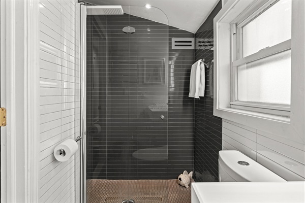 Enjoy the large, walk-in shower with elegant tile work and modern amenities.