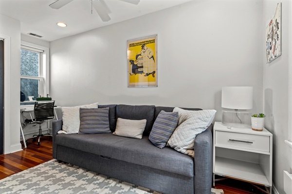 Relax in this bright living room with a comfortable sofa, accent pillows, and modern artwork.