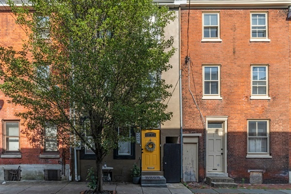 You'll fall in love with this charming townhouse featuring a vibrant yellow door. Nestled on a tree-lined street, it's the perfect blend of historic charm and modern comfort.