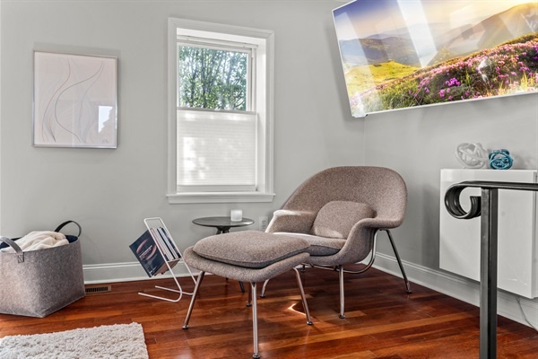 Cozy up in this stylish armchair corner, perfect for reading or enjoying a quiet moment. The natural light and serene decor create a peaceful retreat within your urban adventure.