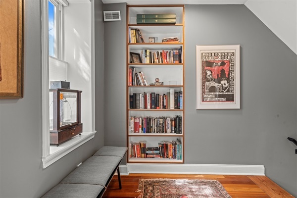 This inviting reading nook features a built-in bookshelf filled with a variety of books, perfect for unwinding with a good read.
