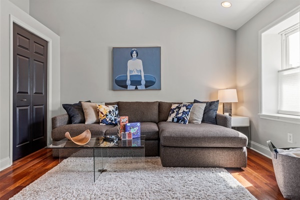 Cozy up in this stylish slick couch, perfect for reading or enjoying a quiet moment. The natural light and serene decor create a peaceful retreat within your urban adventure.