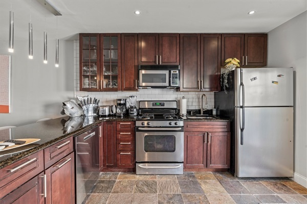 The modern kitchen features stainless steel appliances, granite countertops, and ample cabinet space.