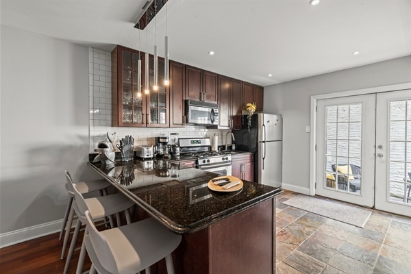 The modern kitchen leads directly to the outdoor patio through beautiful French doors.