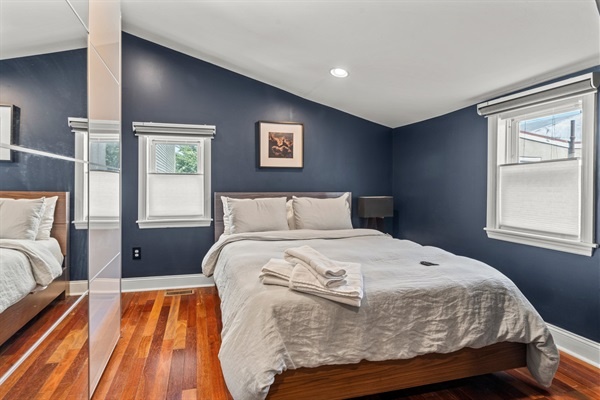 This cozy bedroom features a comfortable bed, soft linens, and dark blue accent walls for a restful night’s sleep.