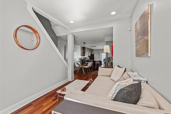 Relax in this inviting living room that seamlessly flows into a modern kitchen, perfect for entertaining or unwinding after a day of exploring Fishtown.