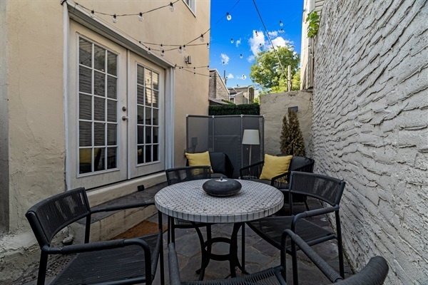 The cozy outdoor patio is perfect for al fresco dining or relaxing under the string lights.