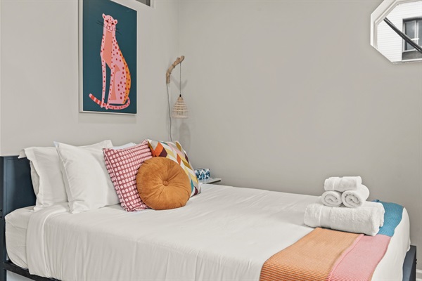 A perfectly designed sleep space — crisp linens, artistic flair, and modern lighting for your unwind.