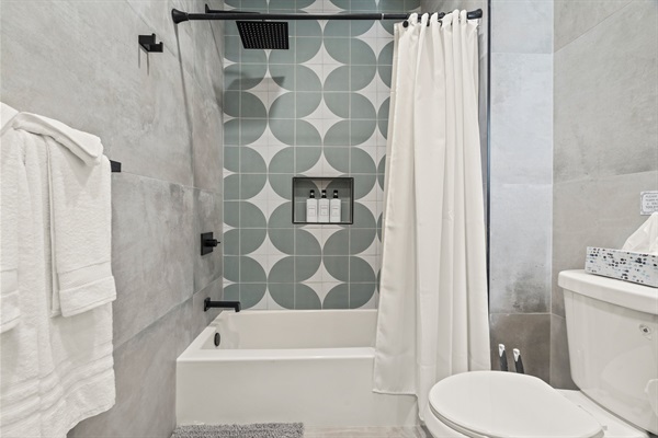 Refresh and recharge in this beautifully tiled bath with luxe rain shower and stocked essentials.
